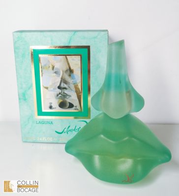 un flacon de parfum posé devant une boîte sur laquelle figure l'image d'une femme