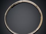 a close up of a silver bracelet on a black surface