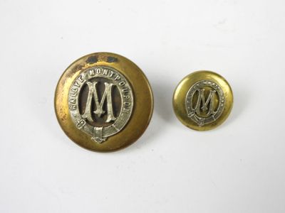une paire de boutons en laiton portant la lettre « m »