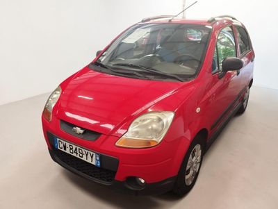 a red car that is parked in a room