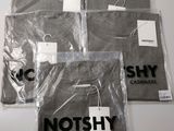 trois t-shirts sont emballés dans des sacs en plastique sur une table