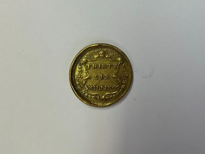 gros plan d'une pièce d'or sur une surface blanche
