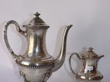 une théière en argent et une autre théière en argent posées sur une table