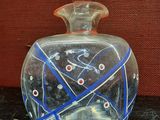 a clear glass bottle with a blue and red design on it