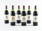 six bottles of wine are lined up in a row on a white surface