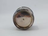 an antique silver plated salt shaker on a white surface