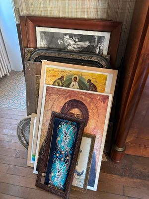 a pile of art on the floor next to a fireplace