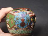 a hand holding a vase with a colorful design on it