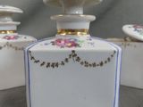 three white vases with flowers on them sitting on a table