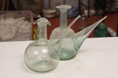 two green glass vases sitting on top of a white table