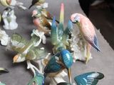 many figurines of birds that are sitting on a table