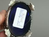 a person holding a blue glass object in their hand