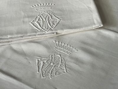deux oreillers ornés de motifs brodés, posés sur un lit