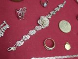 many different types of jewelry on a red cloth
