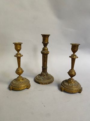 trois bougeoirs anciens en laiton sur fond blanc