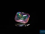 un gros plan d'un diamant coloré sur une surface noire