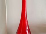 un vase rouge posé sur une table en bois