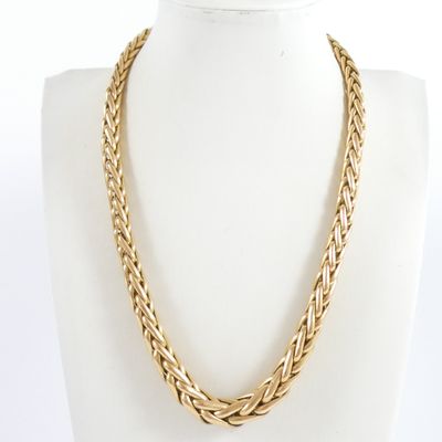 a close up of a gold necklace on a mannequin mannequin