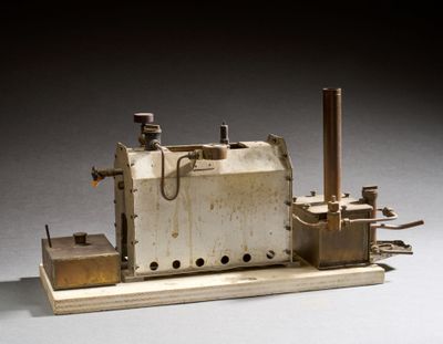 une petite maquette de machine à vapeur posée sur une table