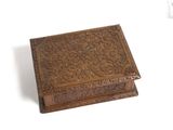 an old wooden box with carvings on it sitting on a white surface