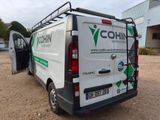 a van that is parked in the dirt with its door open