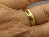 a close up of a person ' s hand with a gold ring on it