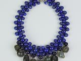 a close up of a necklace with blue beads and a silver clasp