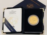 l'image d'une pièce d'or dans une boîte noire ornée d'un ruban bleu