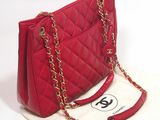 a red purse with a gold chain hanging from it
