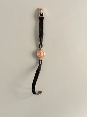 un gros plan d'une montre accrochée à un crochet au mur
