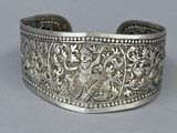 a close up of a silver bracelet with a bird on it