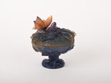 un petit vase surmonté d'un papillon
