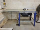 une table sur laquelle est posée une scie, dans une pièce