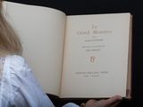 blonde haired woman holding open book in front of black background