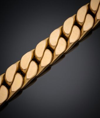gros plan d'un bracelet en or sur fond noir