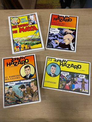 quatre bandes dessinées sont posées les unes à côté des autres sur une table