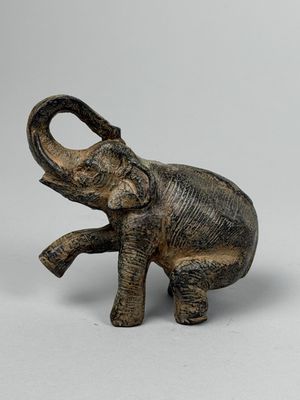statue représentant un éléphant debout sur ses pattes arrière, la trompe levée