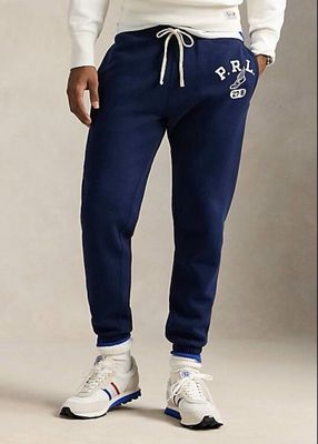 the man is wearing a white sweatshirt and blue sweatpants