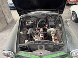 an old car with its hood open and the engine in the trunk