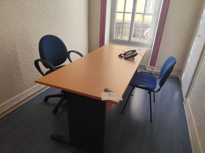 un bureau avec deux chaises et un ordinateur portable dessus