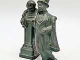 bronze figurine of a man and a woman standing next to each other