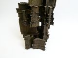 a sculpture made out of wood blocks on a white surface