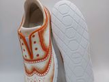 two pairs of shoes with orange and white designs on them