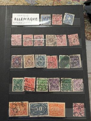 une collection de timbres exposée sur une table, avec une carte en arrière-plan
