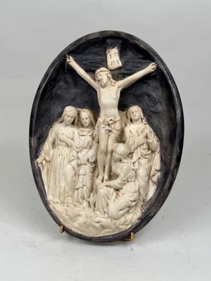 un relief en noir et blanc représentant Jésus sur la croix, entouré de trois femmes