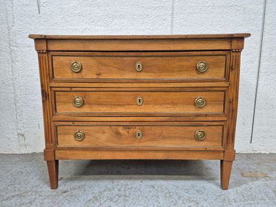 une commode en bois munie de poignées en laiton