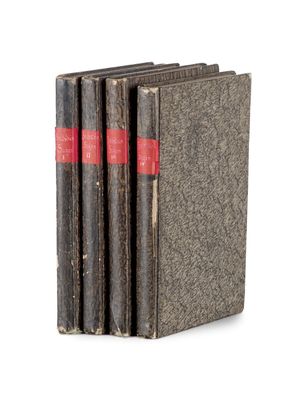 trois vieux livres sont empilés sur une surface blanche
