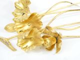 a close up of a gold hair comb with flowers on it