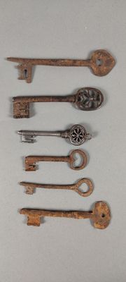 several old keys are sitting on a white surface next to each other
