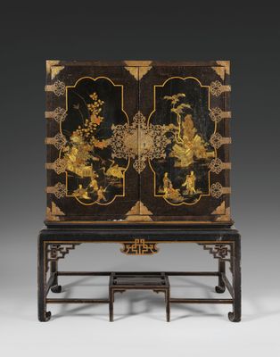 a black and gold decorated cabinet on stand